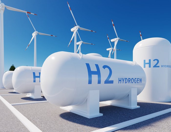 Wasserstofftank mit Windenergieanlagen im Hintergrund